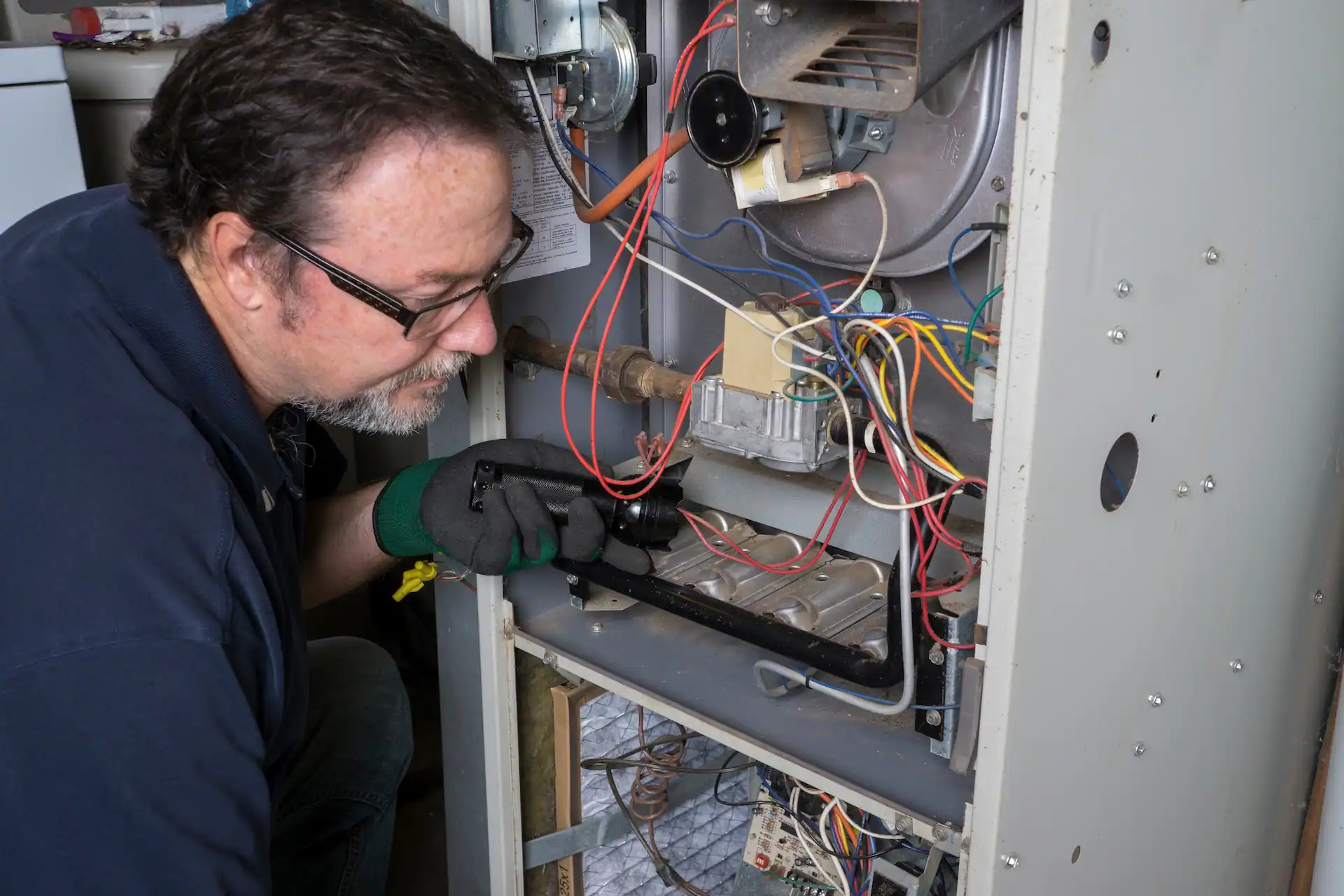  Technician Looking Over A Gas Furnace 